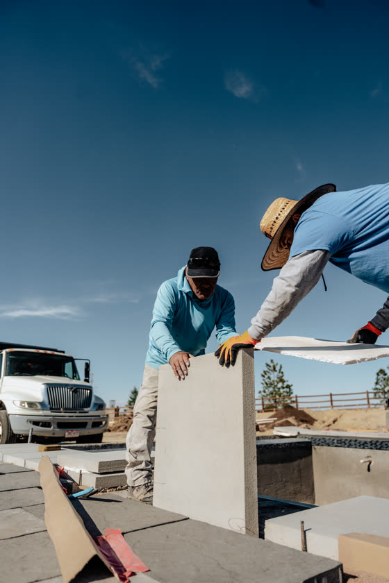 Crew setting a precast panel beside a delivery truck