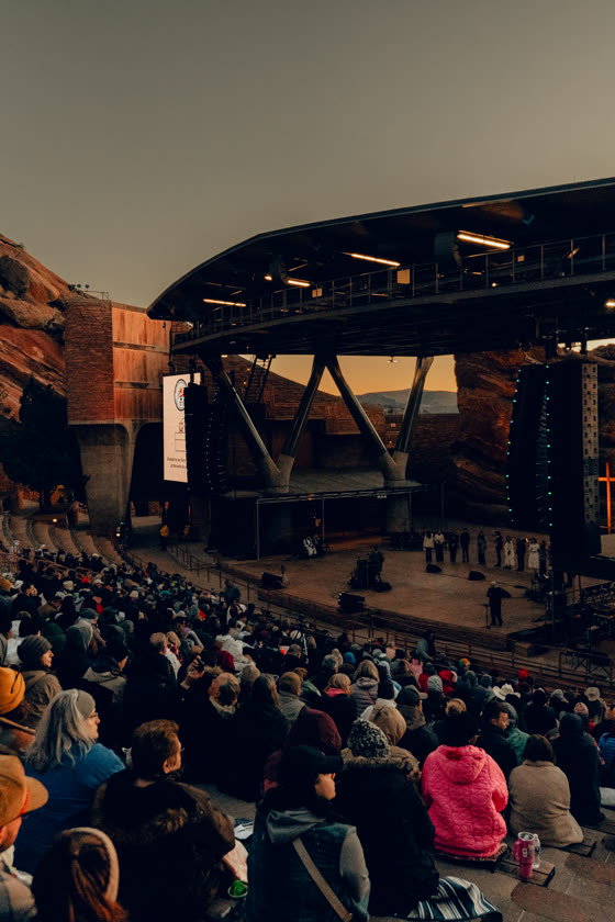 Crowd filling an open-air Colorado amphitheatre before a show
