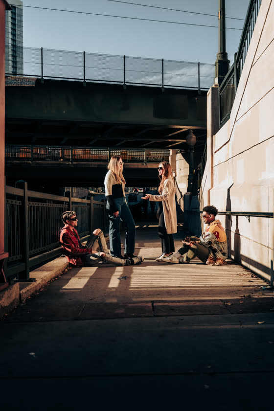 Friends gathered under a bridge on a downtown afternoon