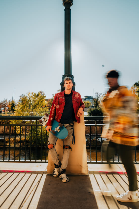 Skater posted up on an urban walkway in golden light